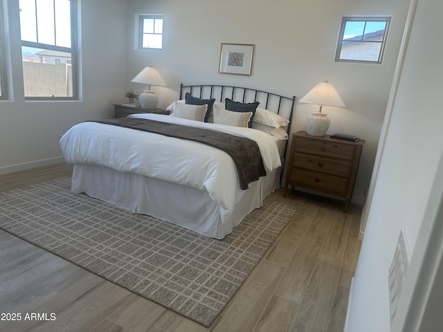 bedroom with baseboards and wood finished floors