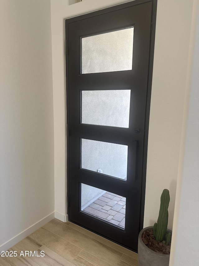 interior space with baseboards and wood finished floors