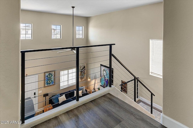 staircase featuring baseboards and wood finished floors