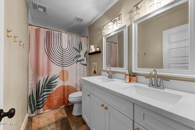 bathroom featuring a sink, toilet, and visible vents