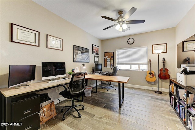 office space featuring baseboards, ceiling fan, and light wood finished floors