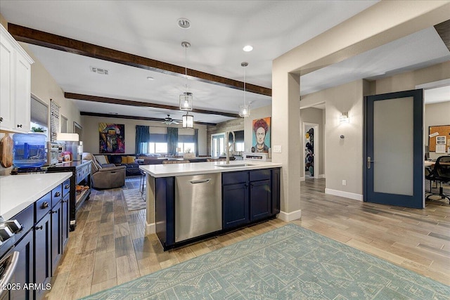 kitchen featuring a sink, white cabinets, light wood finished floors, and open floor plan
