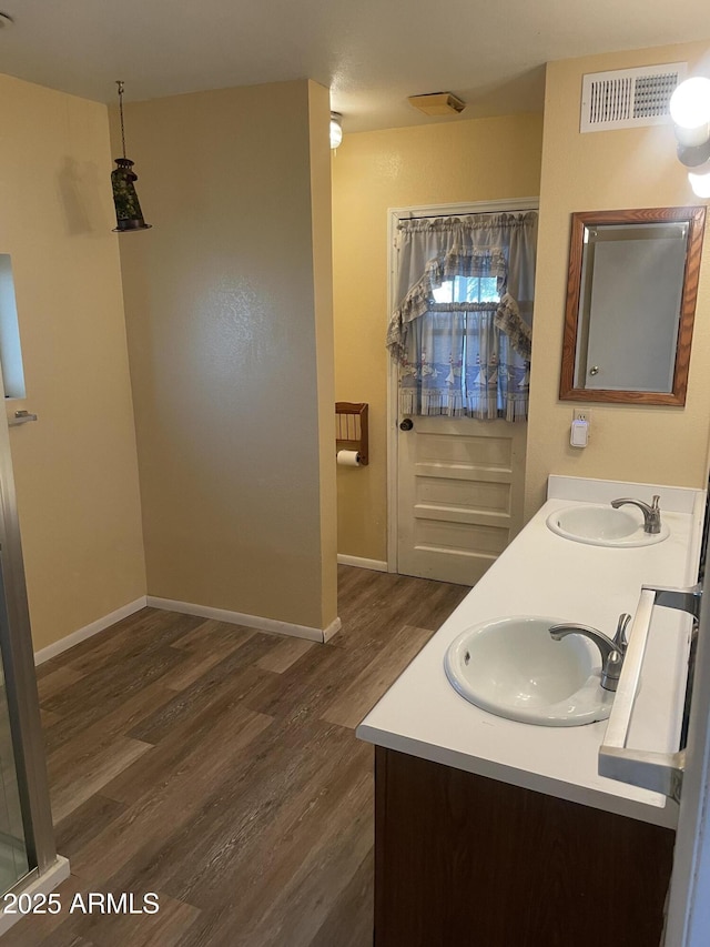 3115 N 26th St, Phoenix, AZ 85016 - full bathroom with wood finished floors, double vanity, and baseboards