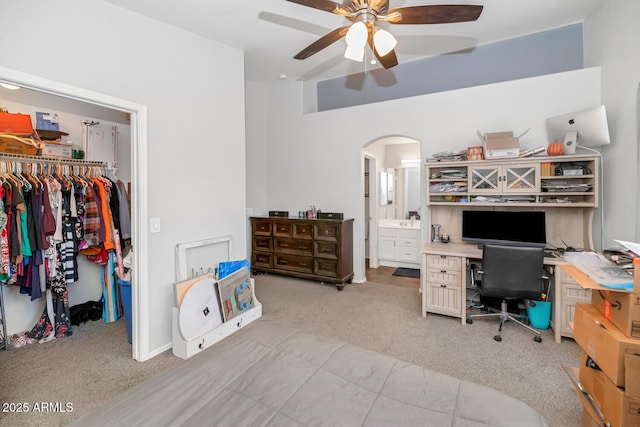 carpeted office space featuring ceiling fan