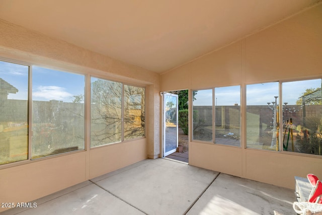 unfurnished sunroom featuring vaulted ceiling and a healthy amount of sunlight