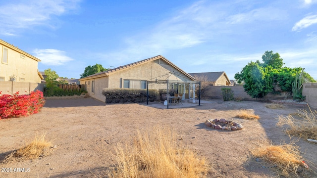 back of house featuring a patio area and a fire pit