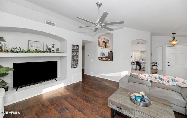 living room featuring ceiling fan, dark wood-type flooring, and built in features