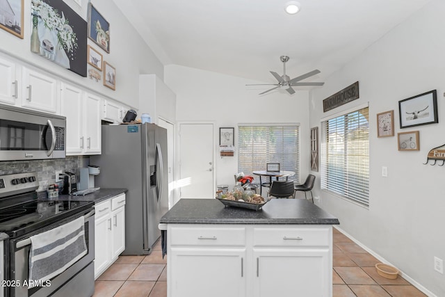 kitchen with appliances with stainless steel finishes, white cabinetry, decorative backsplash, light tile patterned flooring, and ceiling fan