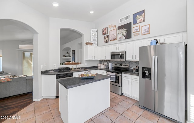 kitchen with sink, light tile patterned floors, a center island, and stainless steel appliances