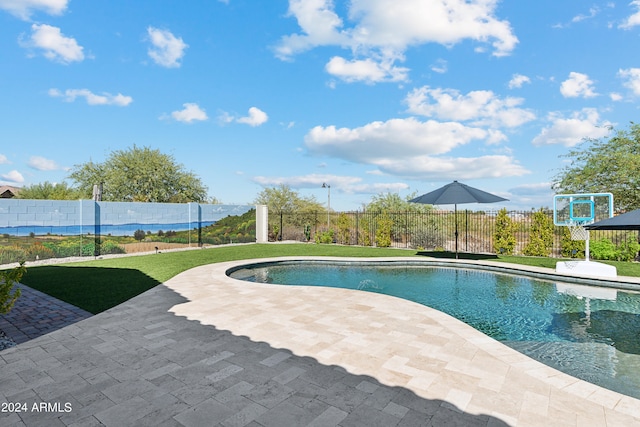 view of swimming pool featuring a lawn and a patio