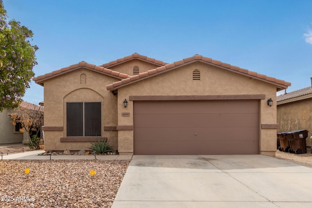 view of front of home with concrete driveway, an attached garage, and stucco siding