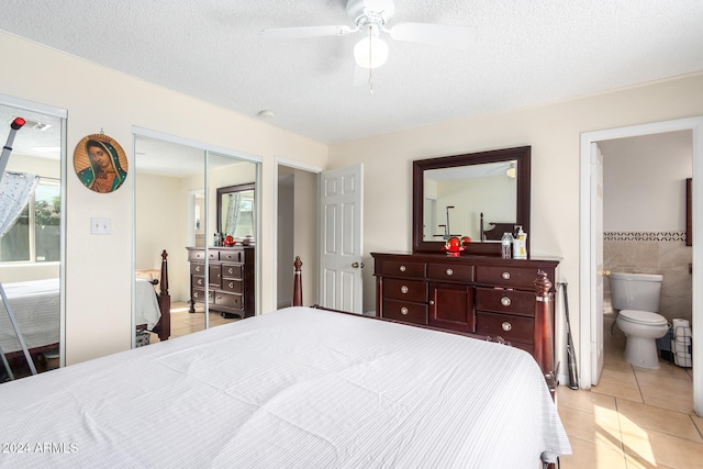 bedroom with ceiling fan, a textured ceiling, light tile patterned floors, and ensuite bath