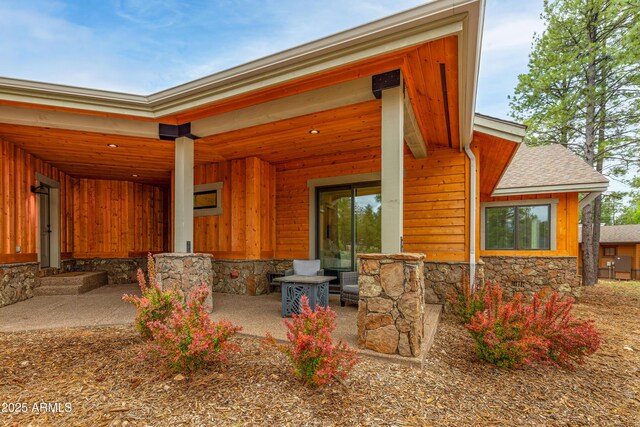 3441 S Del Aire Ct Unit 182, Flagstaff, AZ 86005 - doorway to property with board and batten siding, stone siding, and roof with shingles