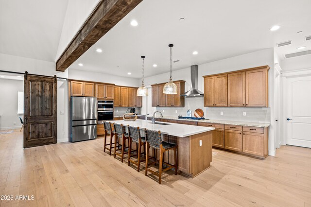 3441 S Del Aire Ct Unit 182, Flagstaff, AZ 86005 - kitchen with wall chimney range hood, stainless steel appliances, a sink, brown cabinets, and a breakfast bar