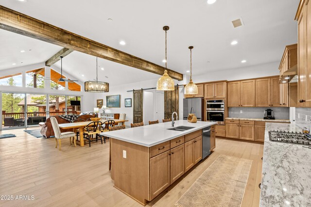 3441 S Del Aire Ct Unit 182, Flagstaff, AZ 86005 - kitchen featuring stainless steel appliances, a sink, a center island with sink, light wood-style flooring, and tasteful backsplash