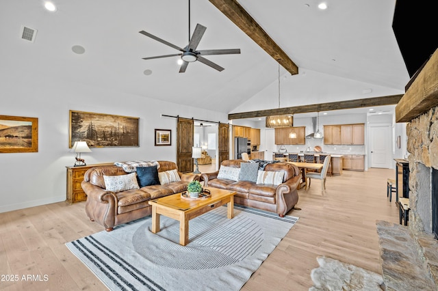 3441 S Del Aire Ct Unit 182, Flagstaff, AZ 86005 - living room featuring a barn door, beamed ceiling, a ceiling fan, light wood finished floors, and high vaulted ceiling