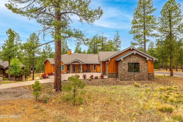 3441 S Del Aire Ct Unit 182, Flagstaff, AZ 86005 - view of front facade featuring stone siding, driveway, a chimney, and board and batten siding