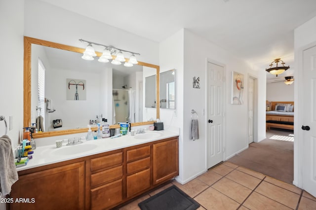 bathroom featuring tile patterned flooring, a shower with shower door, and vanity