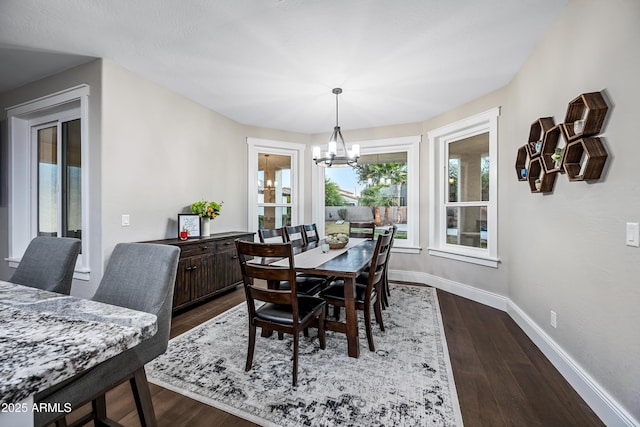 dining space with dark wood-type flooring and a chandelier