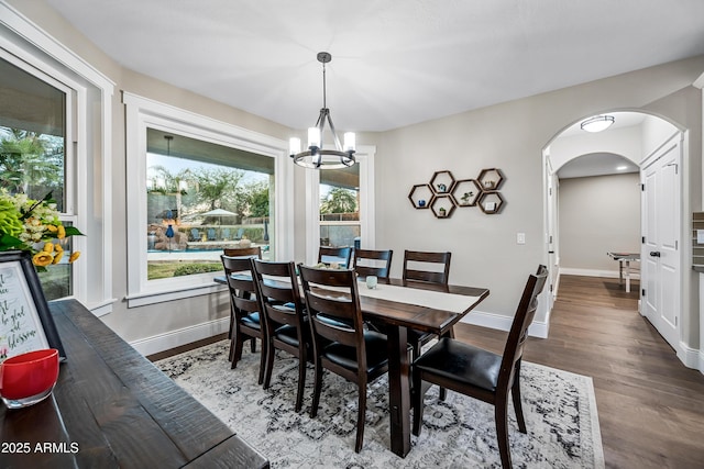 dining space featuring hardwood / wood-style floors and an inviting chandelier