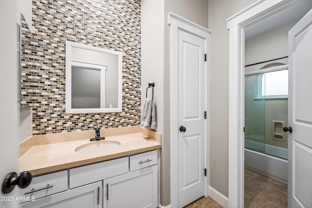 bathroom featuring tile patterned floors, decorative backsplash, vanity, and enclosed tub / shower combo