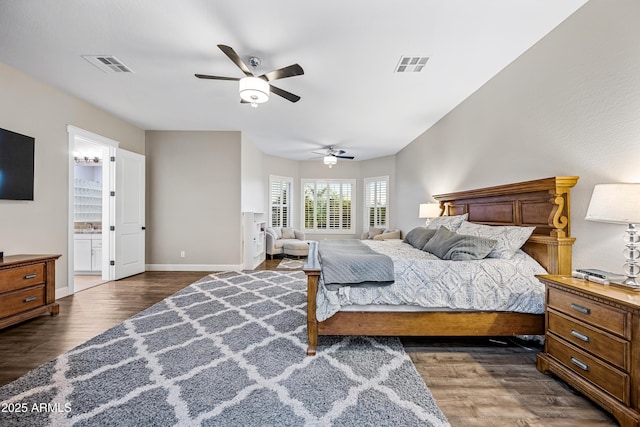 bedroom featuring ceiling fan, dark hardwood / wood-style flooring, and ensuite bath