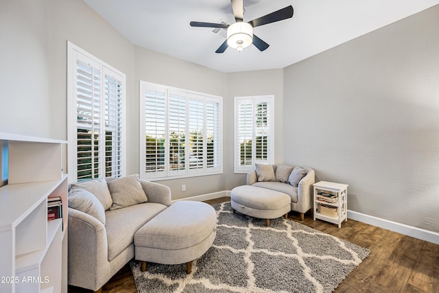 living area featuring ceiling fan and dark wood-type flooring