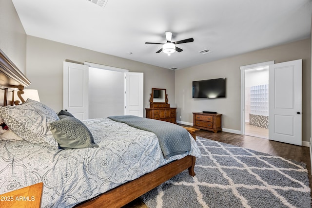 bedroom featuring dark hardwood / wood-style flooring, ensuite bathroom, and ceiling fan