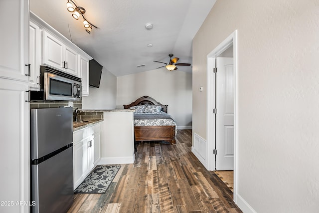 kitchen featuring appliances with stainless steel finishes, dark hardwood / wood-style flooring, ceiling fan, stone counters, and white cabinetry