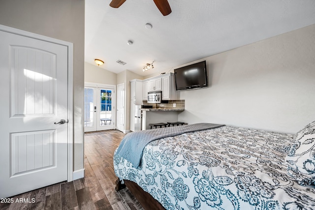 bedroom featuring access to exterior, ceiling fan, dark hardwood / wood-style flooring, and vaulted ceiling