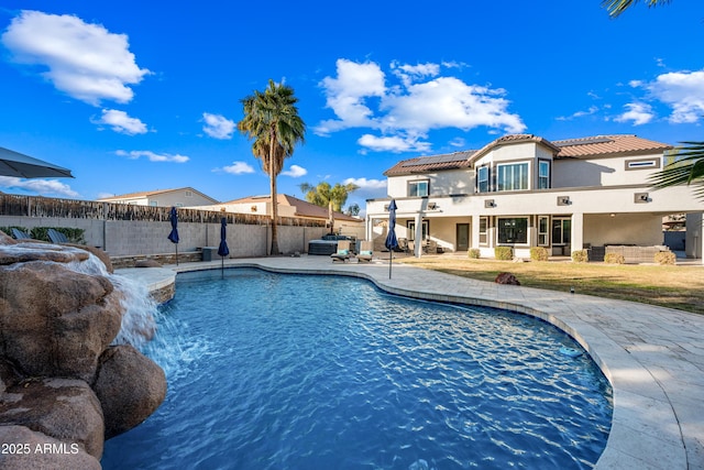 view of pool featuring a patio area, pool water feature, a hot tub, and an outdoor living space