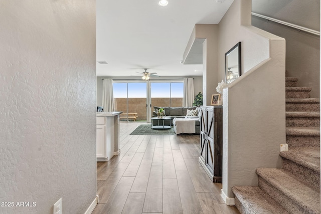 2237 S Jacana Ln, Gilbert, AZ 85295 - hallway featuring light wood-type flooring, a textured wall, stairs, and baseboards