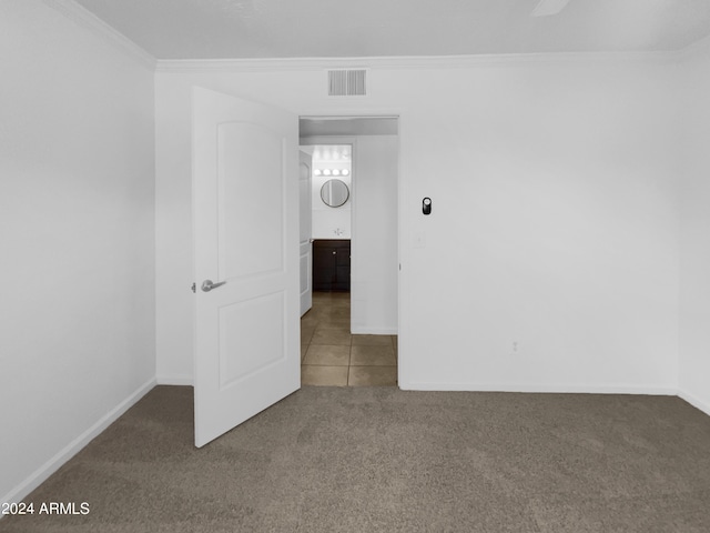 empty room with ornamental molding and carpet flooring