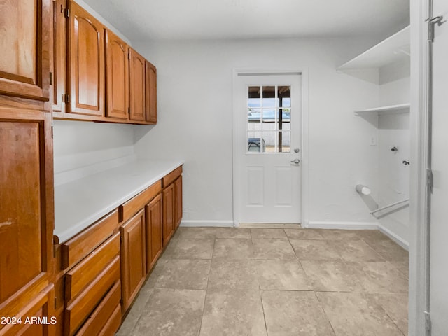 clothes washing area featuring cabinets and light tile patterned floors