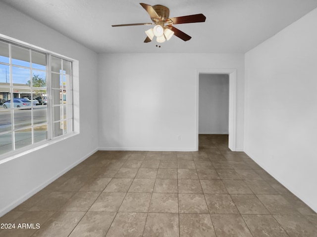 tiled spare room with ceiling fan