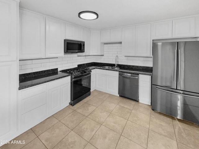 kitchen featuring appliances with stainless steel finishes, white cabinets, sink, backsplash, and light tile patterned floors