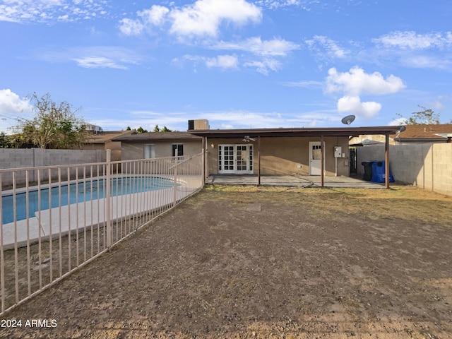 back of property featuring a fenced in pool and a patio area