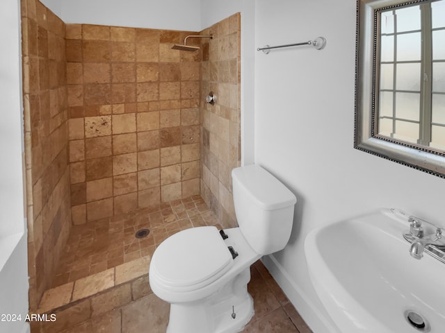 bathroom featuring tiled shower, toilet, tile patterned floors, and sink