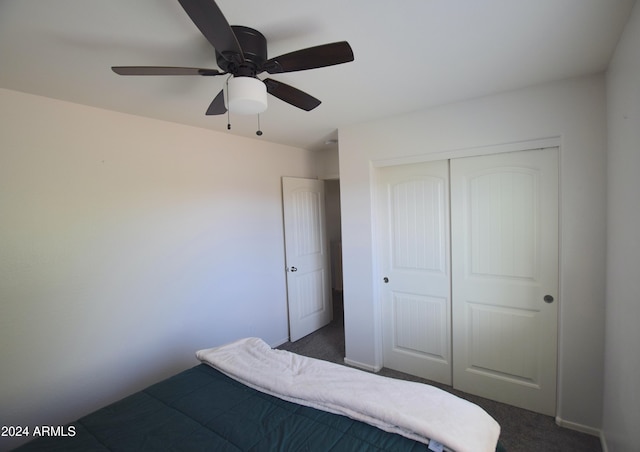 unfurnished bedroom featuring dark colored carpet, ceiling fan, and a closet