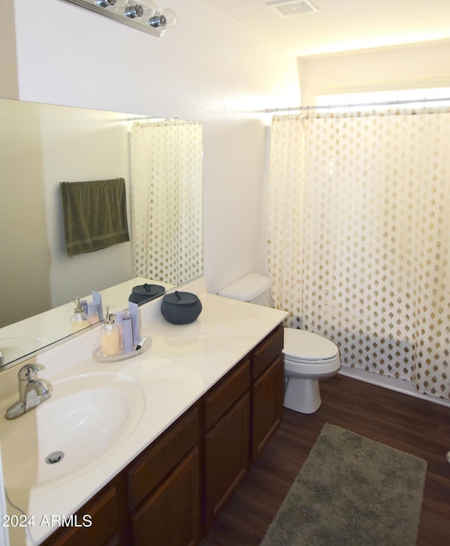 bathroom with hardwood / wood-style floors, vanity, and toilet