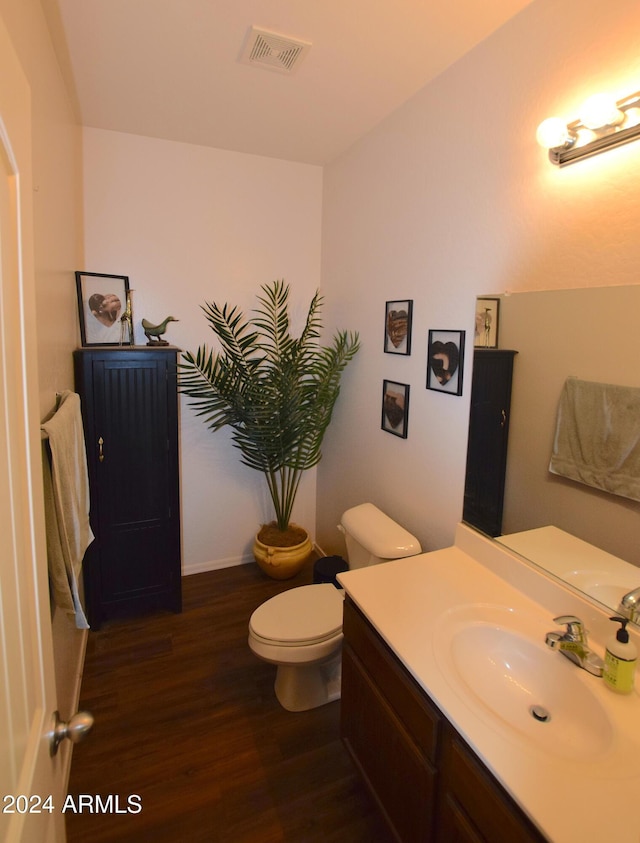 bathroom with vanity, toilet, and wood-type flooring