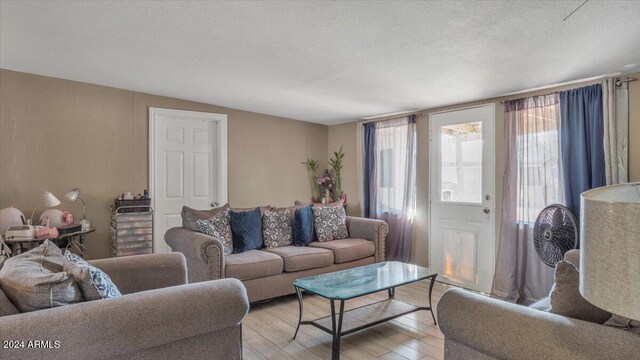 living room with a textured ceiling and light hardwood / wood-style floors