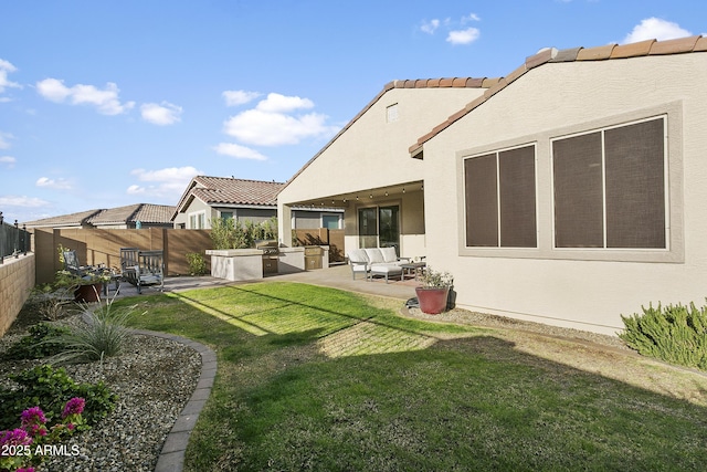 rear view of house with an outdoor living space, a patio area, an outdoor kitchen, and a yard