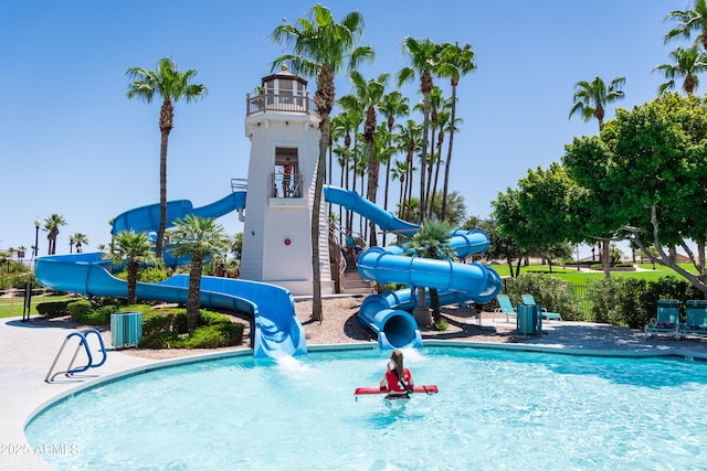 view of swimming pool featuring a playground and a water slide