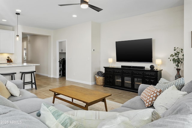 living room with ceiling fan and light hardwood / wood-style floors