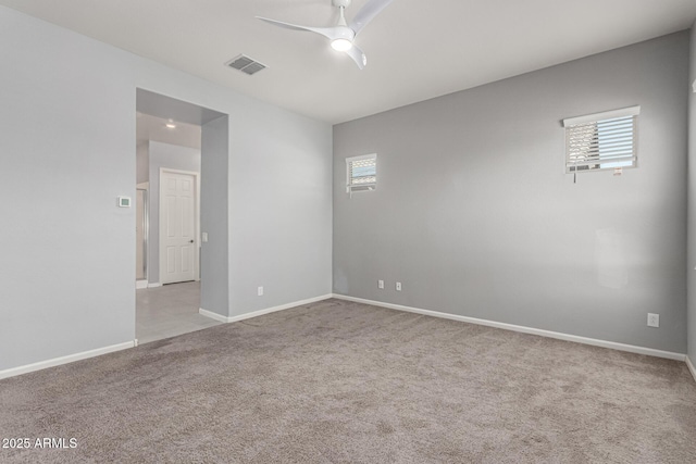 carpeted empty room featuring visible vents, baseboards, and ceiling fan