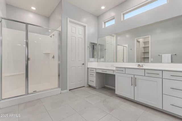 bathroom with vanity, tile patterned flooring, baseboards, and a stall shower