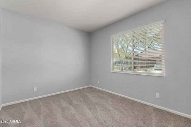 carpeted spare room featuring baseboards