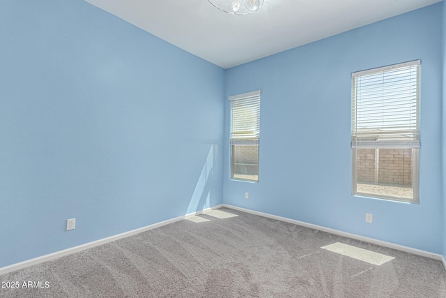 unfurnished room with baseboards and carpet
