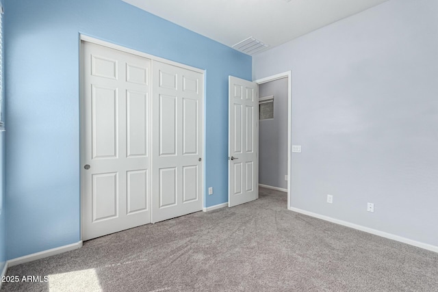 unfurnished bedroom with carpet floors, baseboards, visible vents, and a closet